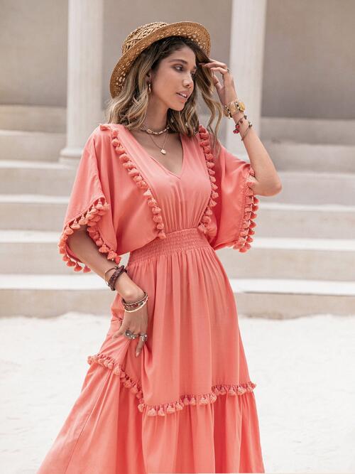The Tassel Trim Smocked V-Neck Short Sleeve Dress from Trendsi Trends is a stylish and versatile piece for every wardrobe. Its elegant tassel accents and flattering smocked design make it a must-have for any occasion.
