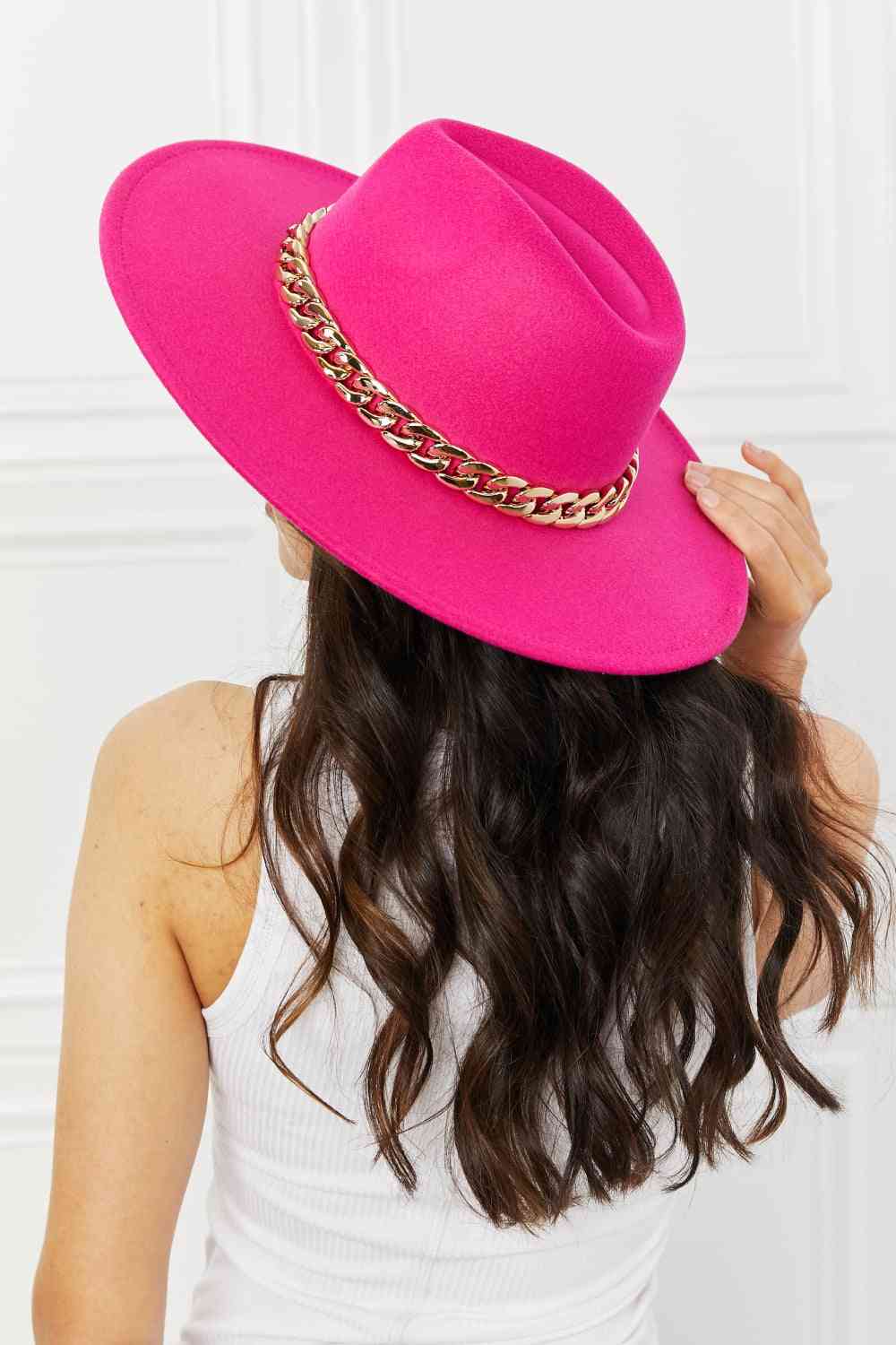 In a vibrant shade of fuchsia, this Fedora hat from Trendsi Trends brings an exquisite pop of color to any understated outfit. The refined design features dainty chain accents and adjustable straps for a flawless fit. Add a touch of opulence to your look with this chic and fashionable accessory.