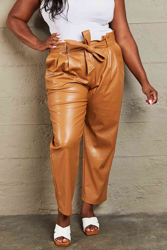 Experience luxurious comfort and a flattering fit with these pants. The paper bag waist design adds sophistication, and the stretchy fabric allows for unrestricted movement all day. These versatile pants include a chic waist belt, perfect for dressing up for a night out or keeping it trendy for a casual look. Upgrade your wardrobe with these essential faux leather pants that seamlessly blend fashion and functionality.